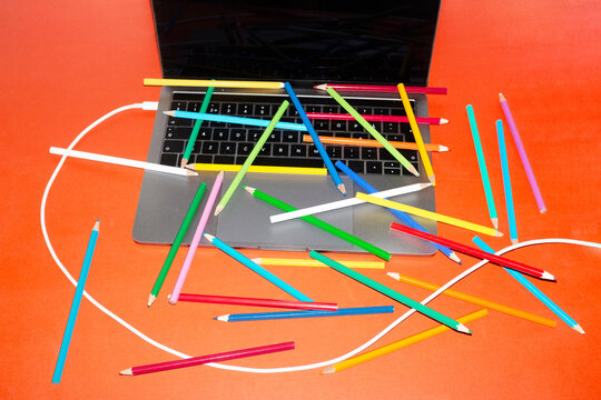 Office desk with laptop and colorful pencils with direct flashlight