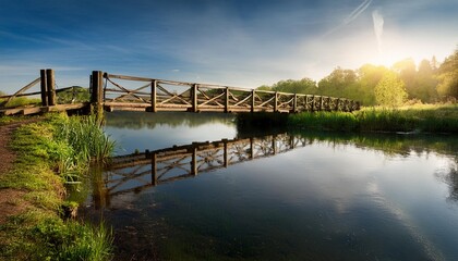 Fototapeta premium Rustic Wooden Bridge Over a Calm River