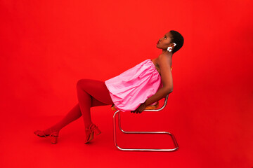 Black woman leaning on chair in studio