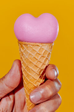heart-shaped ice cream cone in the hand of a man