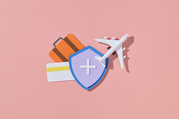 Travel Insurance Concept with Airplane and Luggage on Pink Background