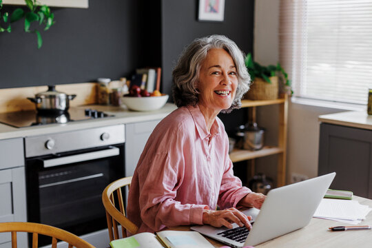 Happy woman working remotely from home using laptop