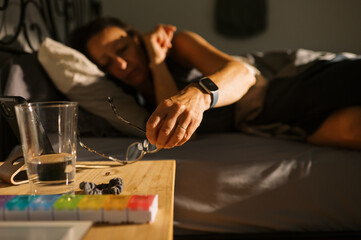 woman waking up from sleep in the morning and getting eyeglasses
