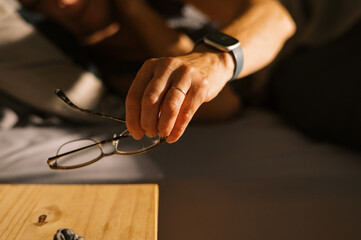 woman waking up from sleep in the morning and getting eyeglasses