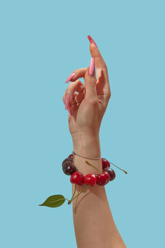 Woman hand with pink nails showing cherry bracelet around wrist