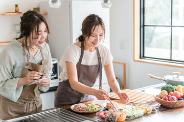 料理教室・クッキングスクールで料理を教える講師の女性と生徒の女性
