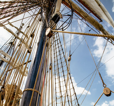 Ship Mast and Ropes Under a Cloudy Sky