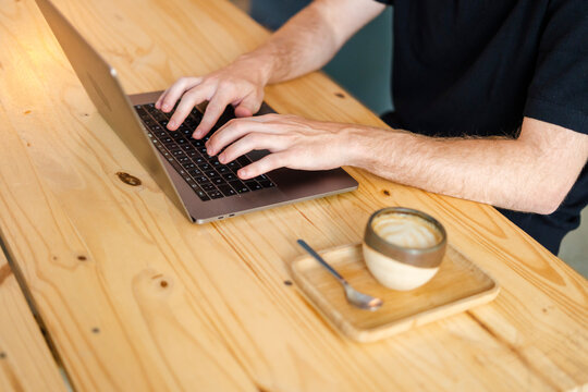 Man Working On Laptop From A Cafe