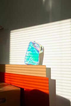 Sparky shiny hologram clutch with golden hour beam of light / sunrays