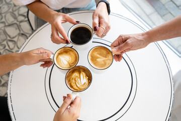 Hands Holding Coffee Cups In A Cafe.