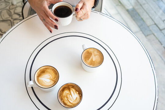 Coffee Gathering Table. Person Holding Coffee Cup With Three Others