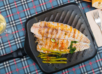 Plate of tasty fish dish - slices of roasted sea bass with asparagus