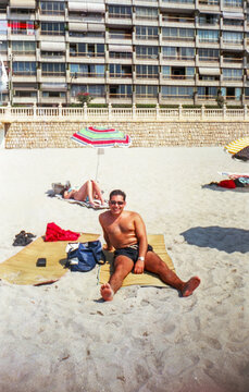 Analog image of a man on the beach in Benidorm, Spain in the 90s