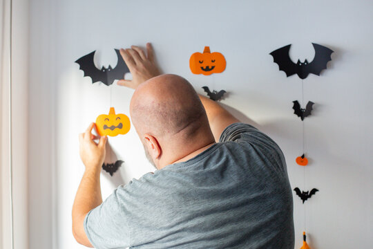 man decorates the wall before halloween holidays