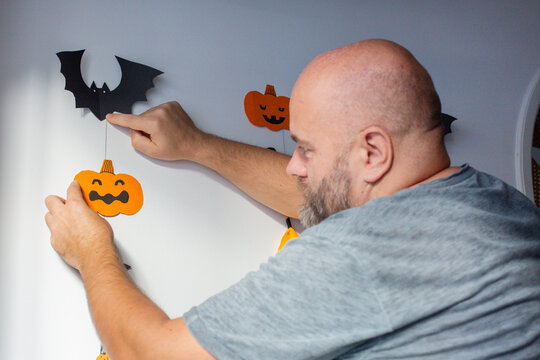 man decorates the wall before halloween holidays