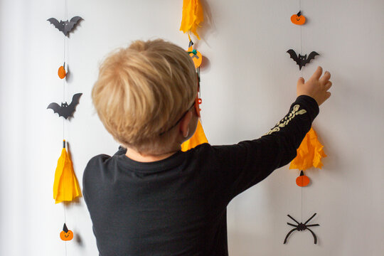 boy decorates the wall before halloween holidays