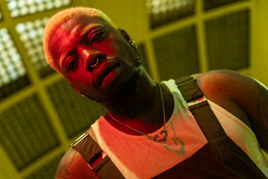 Alternative Man With Blond Hair And Tattoos In Cinematic Lighting