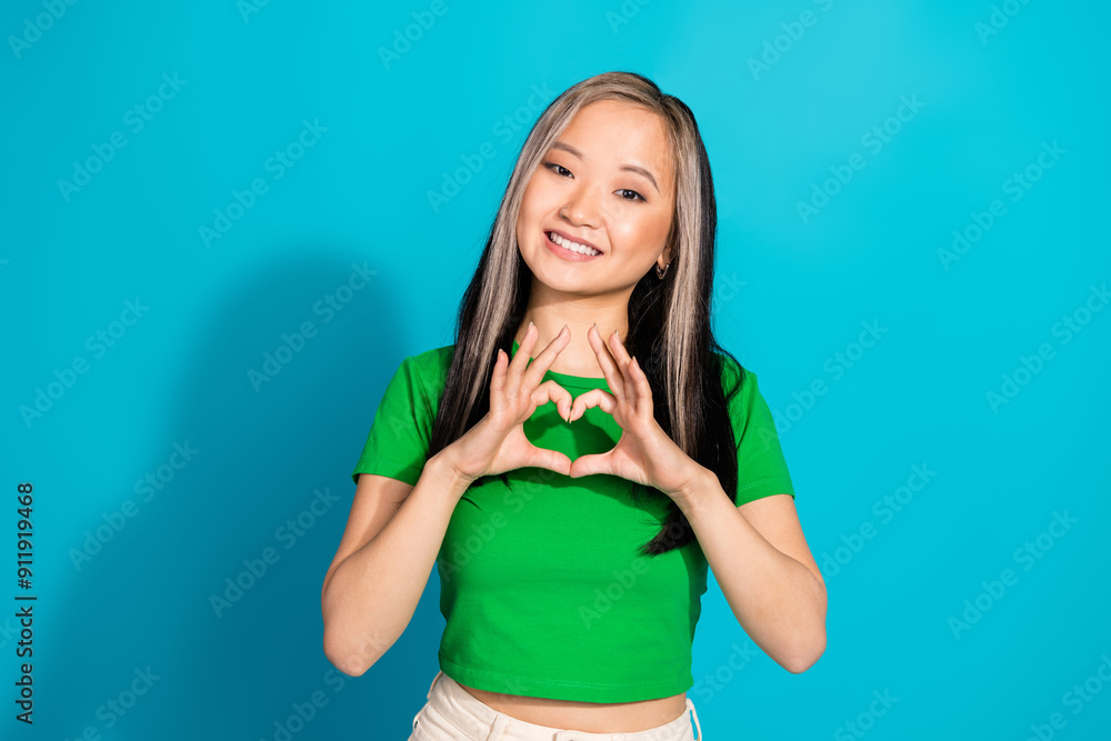 Wall mural Photo of lovely young girl show heart symbol wear t-shirt isolated on teal color background