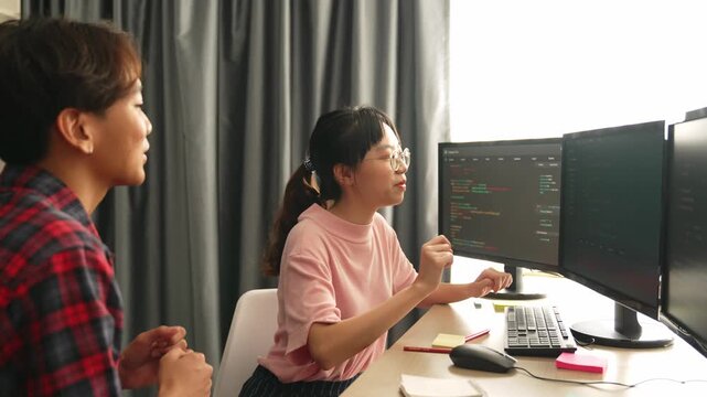 Slow motion back end software developer engineer for computer programming working together on debugging writing computing code, solving complex algorithms display on monitor in office. Burgeoning