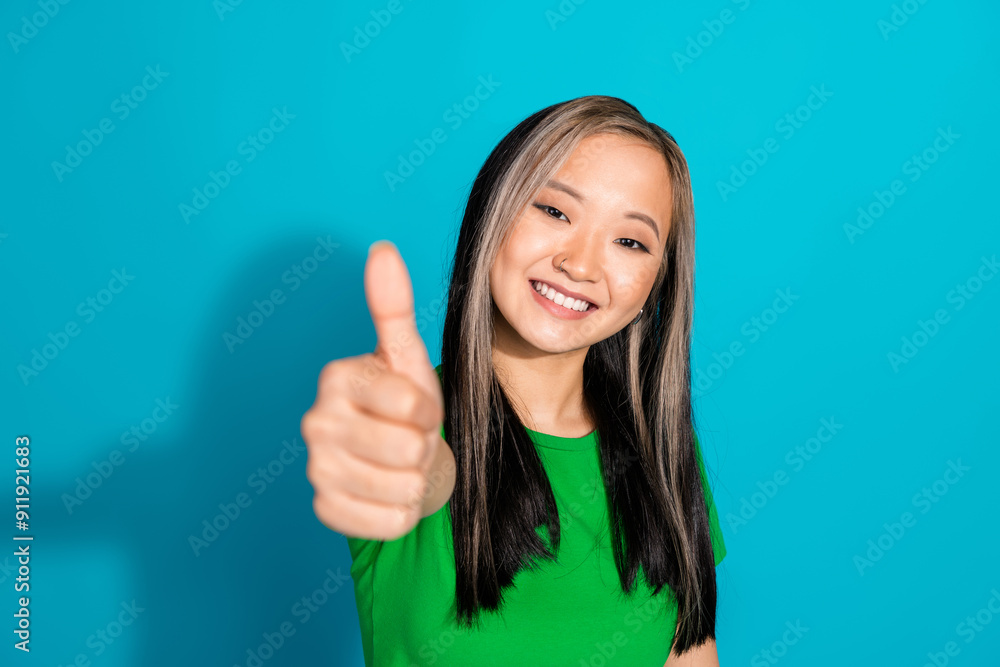 Wall mural Photo of lovely young girl demonstrate thumb up wear t-shirt isolated on teal color background