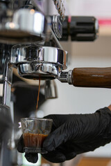 To prepare an espresso, finely ground coffee is used to brew a small, concentrated shot of coffee. The process begins by tamping the coffee grounds tightly into the portafilter. Hot water, under high 