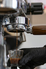 To prepare an espresso, finely ground coffee is used to brew a small, concentrated shot of coffee. The process begins by tamping the coffee grounds tightly into the portafilter. Hot water, under high 