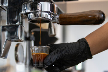 To prepare an espresso, finely ground coffee is used to brew a small, concentrated shot of coffee. The process begins by tamping the coffee grounds tightly into the portafilter. Hot water, under high 