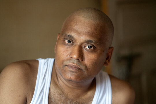 Portrait of a bald headed man who recently loss his father