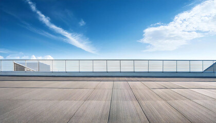 Fototapeta premium 晴れた校舎の屋上。コンクリート、手すり、青空のある屋上の風景。A sunny day on the roof of a school building. A rooftop view with concrete, railings and blue sky.