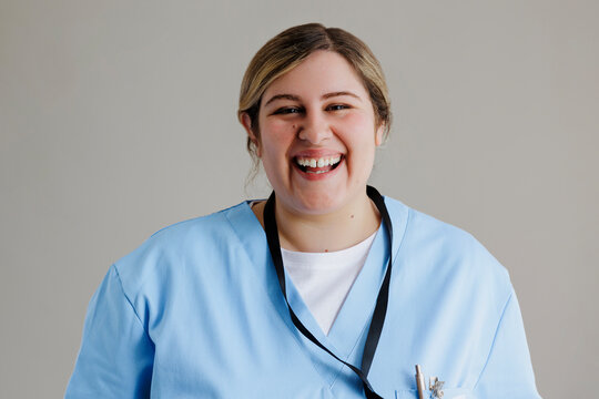 Young female doctor smiling wearing blue scrubs in studio