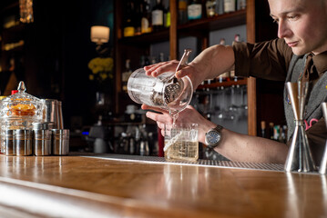Bartender prepares cocktail at the bar counter