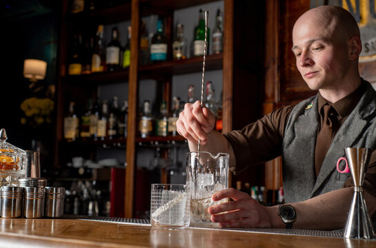 Bartender prepares cocktail at the bar counter