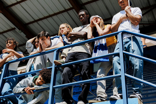 Group of friends feeling disappointed watching sports event