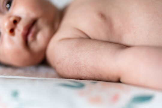 Newborn baby lying down showing lanugo on skin