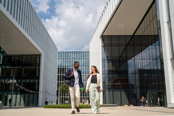 Smiling Business Partners Outside Modern Glass Building