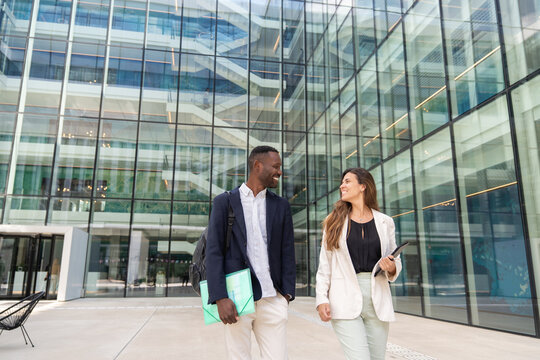 Businessman And Businesswoman Walking Outside Office