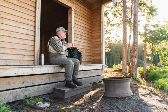 Fisherman Relaxing by Forest Cabin