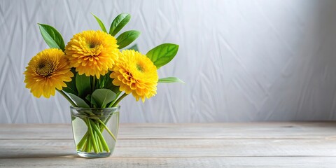 Fototapeta premium Flower arrangement with three yellow flowers and green leaves, yellow flowers, green leaves, floral arrangement