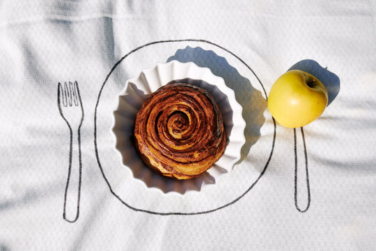 Tablecloth with plate with cinnamon bun