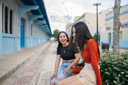 Women Laughing outside sit on bench