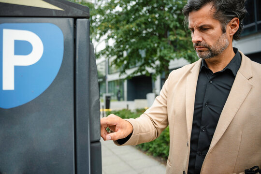 A man pays for parking at a vending machine