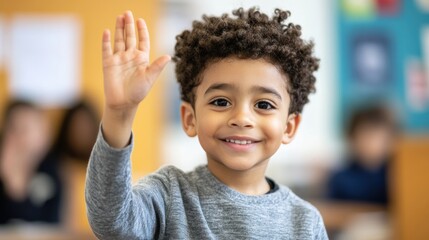 A smiling boy eagerly raises his hand in class, ready to answer a question