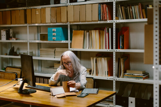 Senior woman sitting in office working on pc