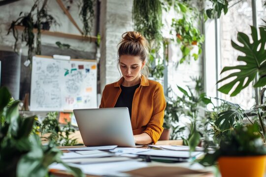 businesswoman surrounded by papers and a laptop preparing for a presentation