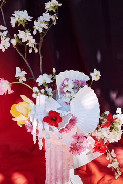 Skeleton Hand Holding Flowers in White Vase