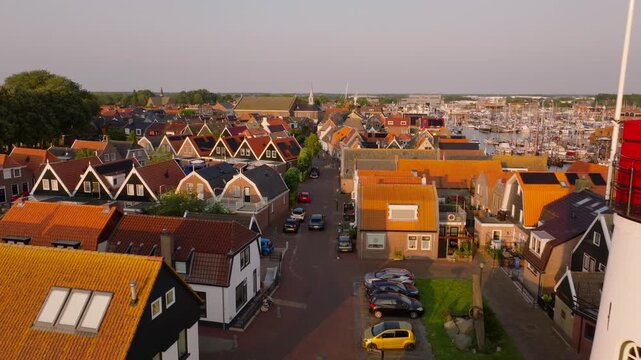 Tranquil beauty of Urk's charming residential neighborhood with its iconic lighthouse and dutch architecture during a serene sunset