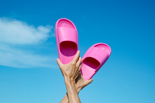 man with a pair of pink sandals in hi hands