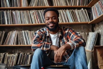 passionate Black hipster with a record player surrounded by vinyl records