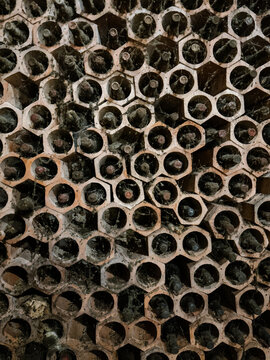 Vintage stacked wine bottles in hexagonal cellar holders