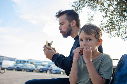 Little son and his father eating outside